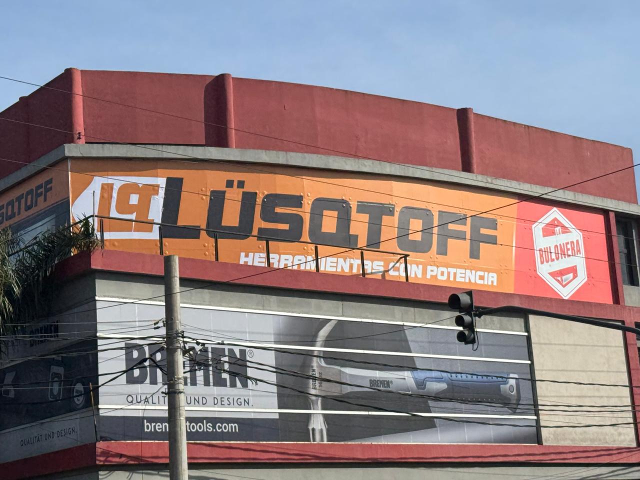 Mega vidriera en altura ploteada de naranja con logo de Lusqtoff